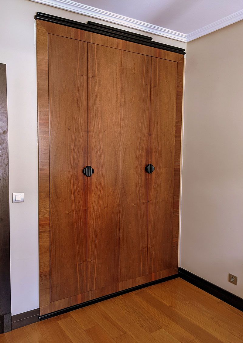 Armario de dos puertas de madera clara con tiradores negros