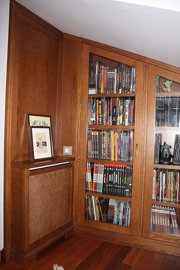 Biblioteca con puertas de cristal adosada a la pared